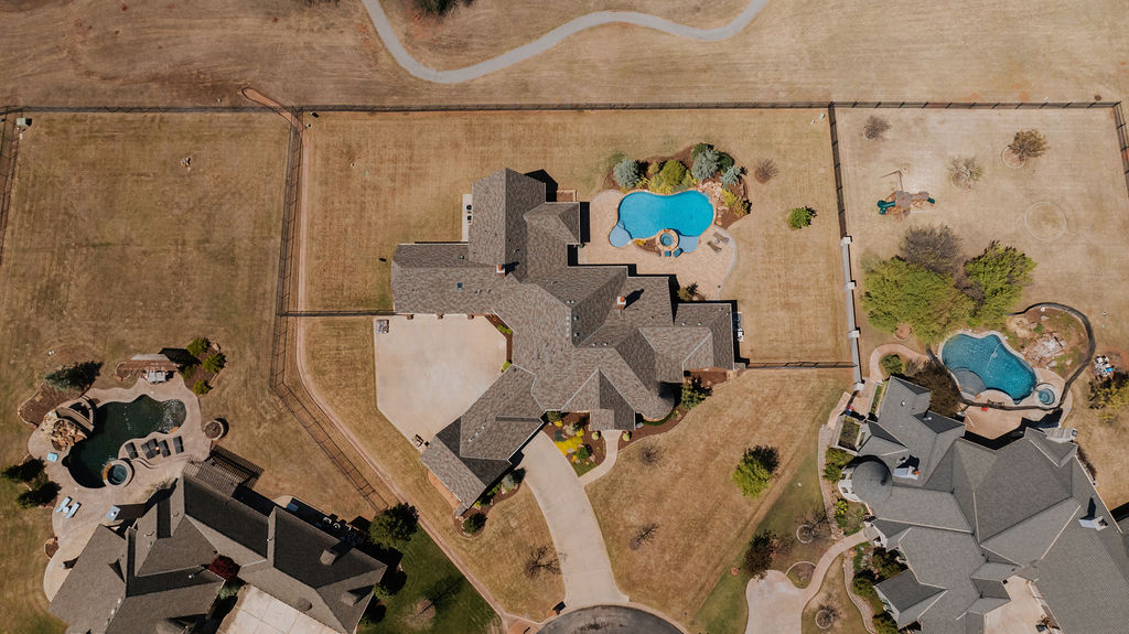 Birds eye view of home with a pool and large fence around the property