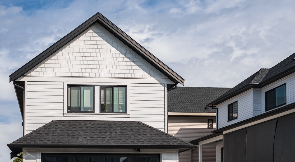 A beautiful suburban home with a freshly installed shingle roof, set against the backdrop of a clear blue sky. The clean, modern look emphasizes durability and aesthetic appeal.